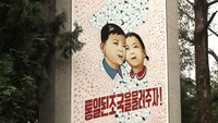 Ini adalah poster propaganda milik Korut. Poster ini berada di setiap sudut Korut. Jangan coba-coba untuk mencopot poster ini sebagai kenang-kenganan atau iseng. Karena kamu akan dipenjara seperti seorang turis Amerika yang bernama Otto Warmbier. Ia di penjara selama 17 bulan di Korut dan dikembalikan ke AS dalam keadaan koma, lalu meninggal. (Koryo Tours)