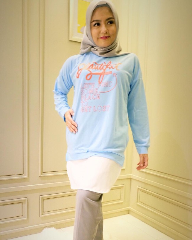 Tika Ramlan tampil santai dengan setelan blouse biru-putih dan kerudung polos. Celana lurus membuat penampilan pelantun Ok itu terlihat kasual. Foto: Dok. Instagram @tika_ramlan