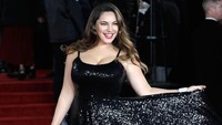 Kelly Brook mengangkat gaun bagian bawahnya saat berpose di karpet merah. Foto: John Phillips/Getty Images