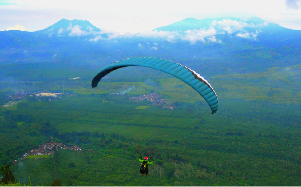 Panorama Manado Skyline yang memukau dengan latar belakang Pegunungan Klabat dan Laut Sulawesi yang biru jernih, menciptakan pemandangan yang tak terlupakan