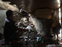 Syarifudin menunjukkan tembok rumahnya yang jebol