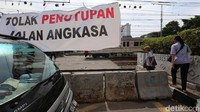 Spanduk protes dibentangkan di perlintasan sebidang kereta api di Jl Angkasa, Kemayoran, Jakarta, Senin (6/11).