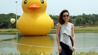 Artis Julie Estelle berpose foto dengan latar belakang patung bebek raksasa. Ia mengaku merasa sangat senang dengan taman dan danau yang asri itu. Foto: dok. Meikarta