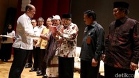Ketua Dewan Pembina Nawacita Institute RM Suryo Atmanto menyerahkan buku 3 Tahun Jokowi kepada Ketua Umum PBNU Said Aqil Siradj dan para undangan.
