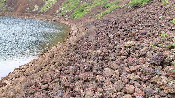 Pada permukaan lereng curam yang mengelilingi danau, hampir semuanya merupakan batu vulkanik merah. Batuan tersebut jarang ditemukan di tempat lain (Thinkstock)