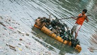 Sampah diangkut ke pinggir sungai menggunakan rakit.