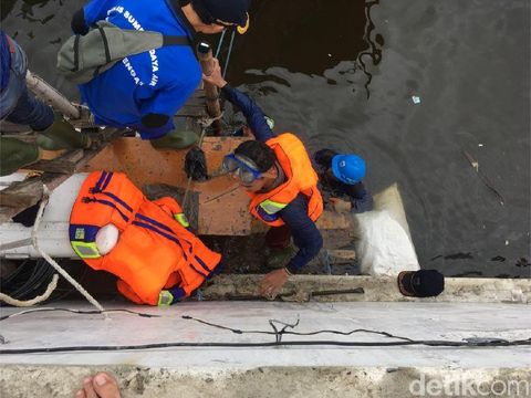 Petugas Sudin SDA menangani tanggul bocor di Luar Batang, Penjaringan, Jakut, Selasa (7/11/2017)