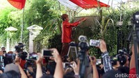 Jokowi menaiki tangga untuk memasang bleketepe.