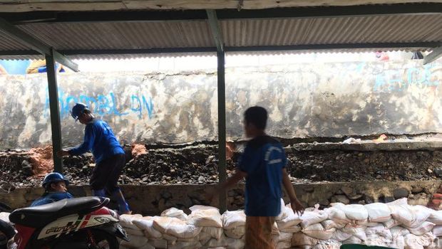  Petugas Sudin SDA menyumbat lubang pada tanggul lama yang bocor hingga membuat air laut menggenangi permukiman warga di Luar Batang, Penjaringan, Jakut, Selasa (11/7/2017)