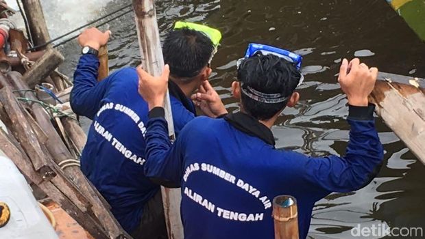 Petugas Sudin SDA menangani tanggul bocor di Luar Batang, Penjaringan, Jakut, Selasa (7/11/2017)