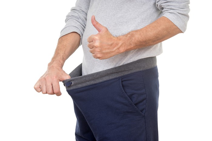 old man looking in his pants and showing thumbs up