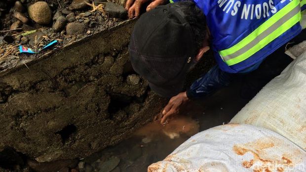  Petugas Sudin SDA menyumbat lubang pada tanggul lama yang bocor hingga membuat air laut menggenangi permukiman warga di Luar Batang, Penjaringan, Jakut, Selasa (11/7/2017)
