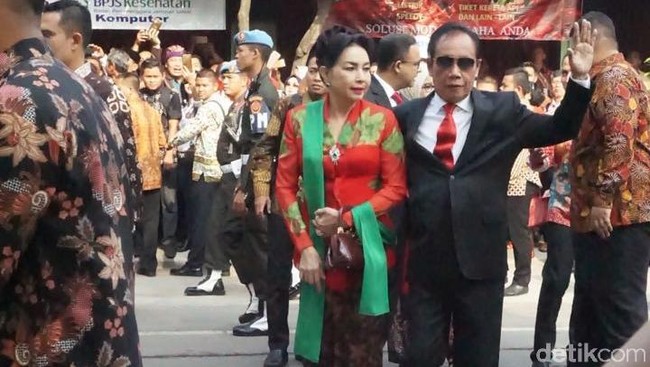Sutiyoso memakai jas hitam dan dasi merah mengikuti warna kebaya kartini sang istri yang menambahkan selendang hijau untuk penampilannya. Foto: detikfoto