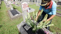 Mereka juga merapikan karangan bunga di tiap makam.