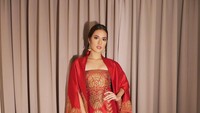 Sebelum ke resepsi Kahiyang, Raisa mengunggah penampilannya di Instagram. Dia memakai dodotan tube dress berwarna merah dengan sentuhan emas dan cape bermotif gunungan. (Foto: Instagram Raisa)