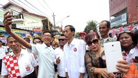 Pria mirip Jokowi lainnya juga menjadi pusat perhatian warga. Banyak warga yang minta foto bersama.
