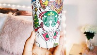 Holiday cup Starbucks tahun ini memuat logo mermaid Starbucks dengan hiasan pohon Natal, merpati, kado dan lainnya dengan warna dasar putih. Netizen ini lalu menggoreskan warna-warna terang pada hiasan tersebut. Foto: Istimewa
