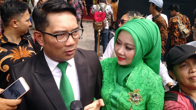 Ridwan Kamil memilih jas di pernikahan Kahiyang Ayu dan Bobby. Warna dasinya menyesuaikan dengan kebaya sang istri, Atalia dengan warna hijau cerah. Foto: Danu Damarjati/detikcom
