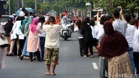 Bahkan warga harus ke tengah jalan demi untuk mengabadikan iring-iringan kereta kencana.