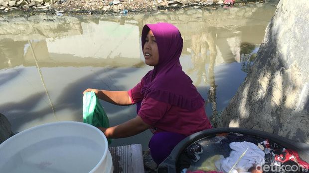 Selain tak ada air PAM, warga memilih mencuci di kali karena air tanah di rumah mereka berasa asin