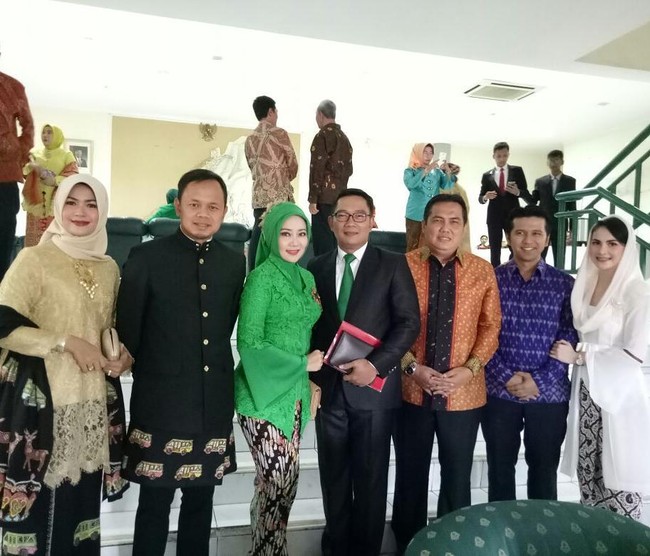 Istri Wali Kota Bandung Ridwan Kamil, Atalia Kamil, tampil dengan gaya hijab simpel menggunakan didominasi warna hijau di pernikahan Kahiyang-Bobby. Ia memakai kebaya kutu baru dengan potongan lengan terompet sehingga memberikan sentuhan modern. Serasi dengan sang suami, Ridwan Kamil juga memakai dasi warna hijau. Foto: Dok. Instagram