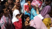 Undangan pernikahan dipakai untuk menutup wajah. Foto: Bayu Ardi Isnanto/detikcom