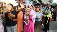 Warga melambaikan tangan kepada calon mempelai.