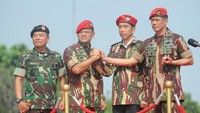 Moeldoko juga memberikan baret dan jaket kepada Jokowi. Suara dentuman meriam 2 kali menandai penyerahan tersebut.