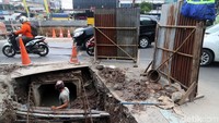 Para pekerja membangun saluran air tepat di bawah Jalan Tanah Tinggi Barat.
