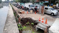 Kendaraan melintas di lokasi proyek pembangunan saluran air di Jalan Tanah Tinggi Barat, Senen, Jakarta Pusat.