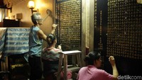 Masyarakat yang tengah menghias kaligrafi di dalam kelenteng. Saat ini kelenteng tersebut memang masih direnovasi (Randy/detikTravel)