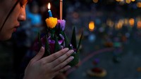 Mereka menghanyutkan krothong, keranjang kecil yang terbuat dari rotan dibentuk menyerupai bunga lotus yang dihiasi dengan bunga, lilin, dan dupa (Reuters)