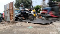 Kendaraan melintas di atas proyek saluran air.
