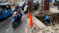 Pembangunan saluran air memakan sebagian badan jalan.
