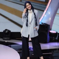 Rina Nose tampil stylish dengan setelan kemeja mullet, celana palazzo hitam, dan striped blazer. Lihat kreasi hijabnya yang membuat penampilan terlihat semakin imut. Ciput ninja menutup leher masih dipakainya pada Agustus 2017. Foto: Dok. Instagram @rinanose16
