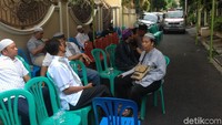 Di luar rumah, sejumlah kaum pria juga tampak duduk di bawah kursi di bawah tenda yang telah terpasang sejak semalam. Sebuah ambulans juga terparkir di lokasi.