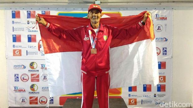 Mbah Dar bersama medali dan bendera Merah Putih. 