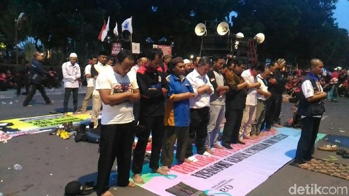 Masih Bertahan di Depan Kemenhub, Massa Buruh Salat Magrib Berjemaah