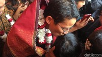 Sandiaga lalu mengecup kening anak perempuan tersebut. Selain CD, jemaat HKBP Cilincing juga memberikan kain ulos, kain khas suku Batak.