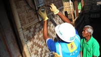 Petugas memasang meteran listrik di rumah warga. Pool/PLN.