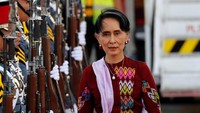 Suu Kyi tampak mengenakan setelan berwarna merah dan selendang putih (Foto: Dok. REUTERS/Erik De Castro)