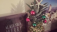 Bola kaca hiasan Natal dengan warna merah hijau ini membuat suasana khas Natal. Hiasan lainnya ditaruh di buah nanas. Bisa memberi suasana meriah di sudut ruangan.Foto: Istimewa