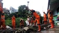 Petugas PPSU menghancurkan tanggul yang telah jebol.