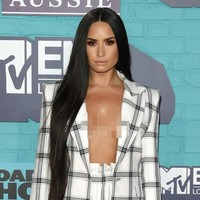 Menyempurnakan gayanya malam itu, pulasan wajah dengan tampilan pucat yang berfokus pada area mata lewat sapuan eyeshadow kemerahan. Sementara rambut panjangnya yang dibiarkan tergerai bebas semakin mempertegas aura seksi perempuan 25 tahun itu. (Foto: Getty Images)