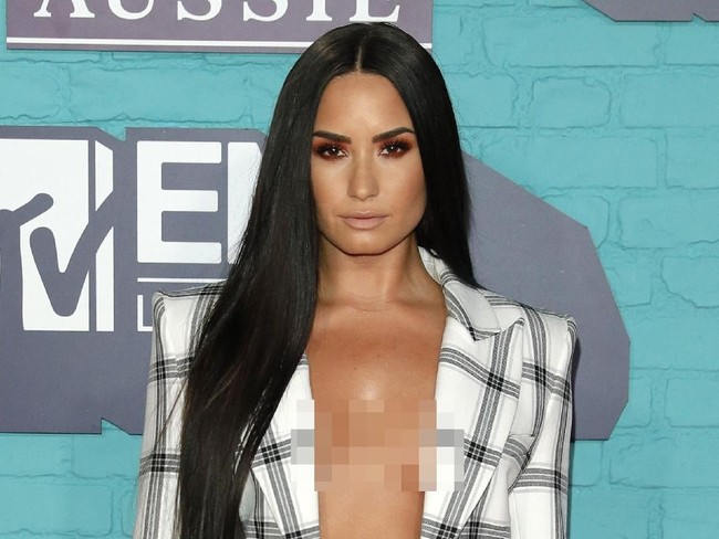 Menyempurnakan gayanya malam itu, pulasan wajah dengan tampilan pucat yang berfokus pada area mata lewat sapuan eyeshadow kemerahan. Sementara rambut panjangnya yang dibiarkan tergerai bebas semakin mempertegas aura seksi perempuan 25 tahun itu. (Foto: Getty Images)