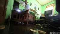Warga melihat ruang tamunya yang masih tergenang.