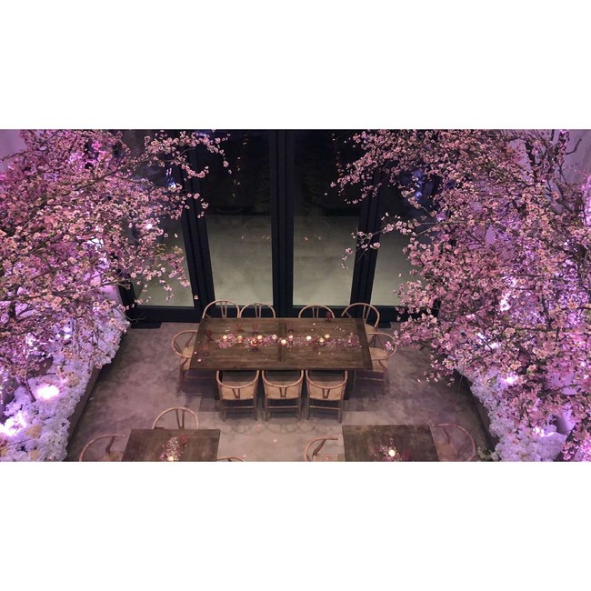 Para tamu pun duduk dengan furnitur kayu di bawah bunga sakura dan mawar putih khas Kanye West sebagai hiasannya. Foto: Dok. Instagram