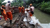 Sejumlah petugas Pekerja Penanganan Sarana dan Prasarana Umum (PPSU) atau pasukan oranye dikerahkan untuk membuat tanggul sementara di RT 03, RW 06 Jatipadang, Jakarta Selatan, Senin (13/11/2017).