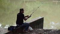 Kebanyakan, masyarakat yang datang ke hutan kota untuk memancing di danau buatan. Mereka asik memancing di pinggir danau. (Foto: Arief Ikhsanudin/detikcom)