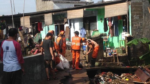 Petugas juga membersihkan sampah-sampah sisa banjir.